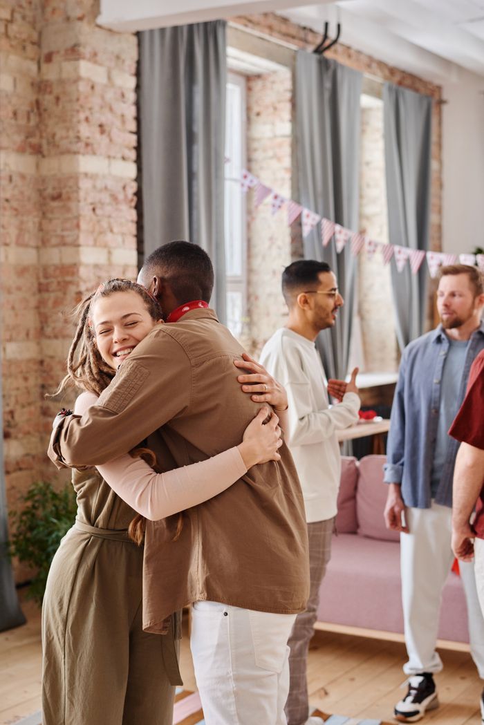 A diverse group of friends celebrating indoors with excitement and togetherness.